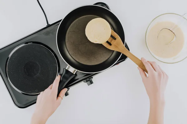 Top view of person cooking pancakes on frying pan on grey — Stock Photo