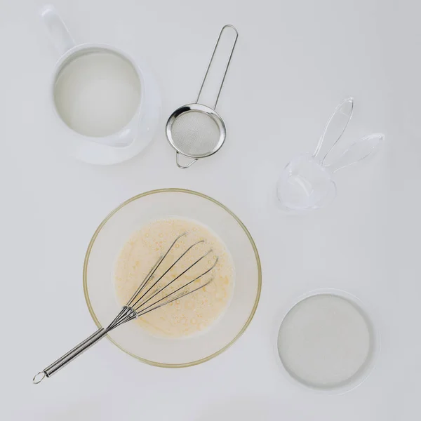 Draufsicht auf Schneebesen und Teig zum Kochen von Pfannkuchen isoliert auf grau — Stockfoto