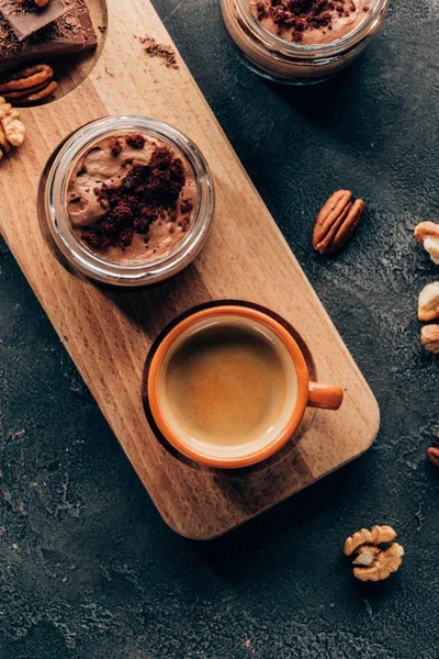 Vista superior de doce deliciosa sobremesa de chocolate e xícara de café em tábua de madeira — Fotografia de Stock