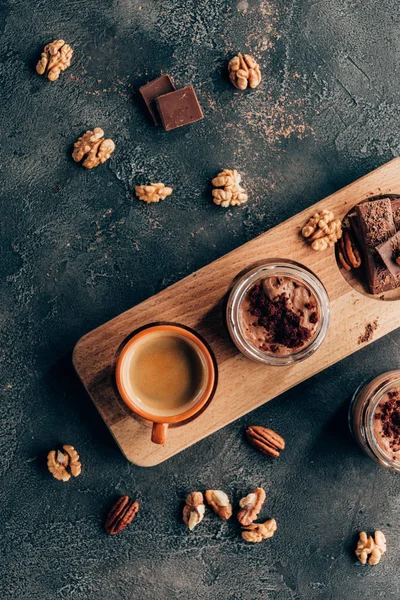 Vista dall'alto di dolce gustoso dessert al cioccolato e tazza di caffè su tavola di legno — Foto stock