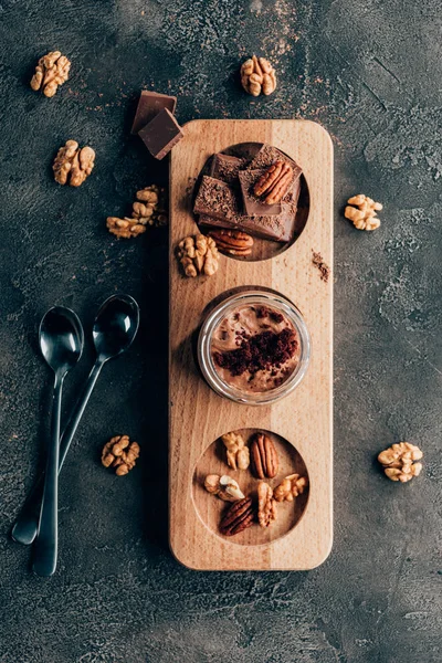 Vue de dessus de délicieux desserts au chocolat sucrés avec des noix sur noir — Photo de stock