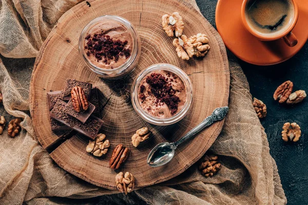 Top view of gourmet tiramisu in glass jars and cup of coffee — Stock Photo