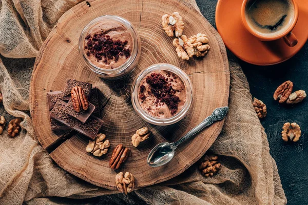 Vue de dessus du tiramisu gastronomique dans des pots en verre et une tasse de café — Photo de stock