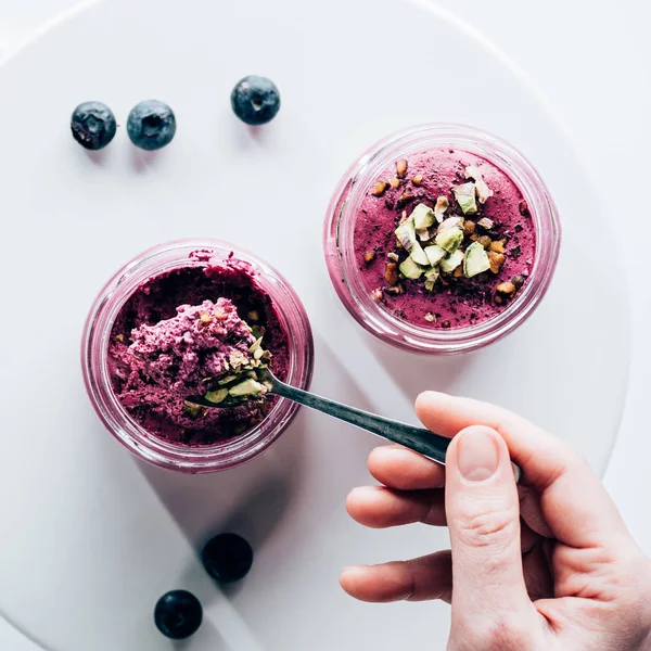 Von oben: Person isst leckeren gesunden Smoothie mit Müsli und Blaubeeren — Stockfoto