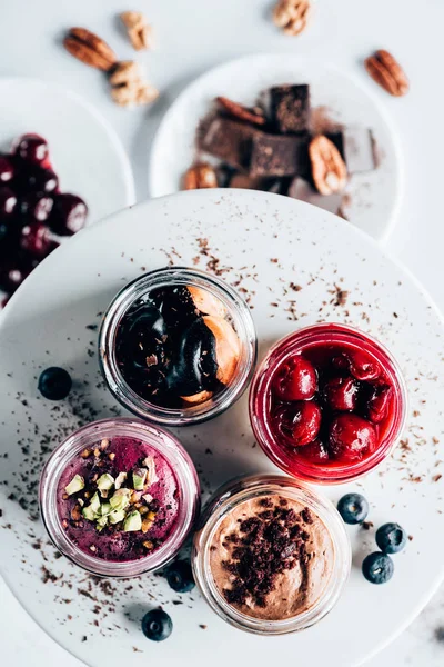Vista dall'alto di vari dolci deliziosi dessert in vasi di vetro — Foto stock