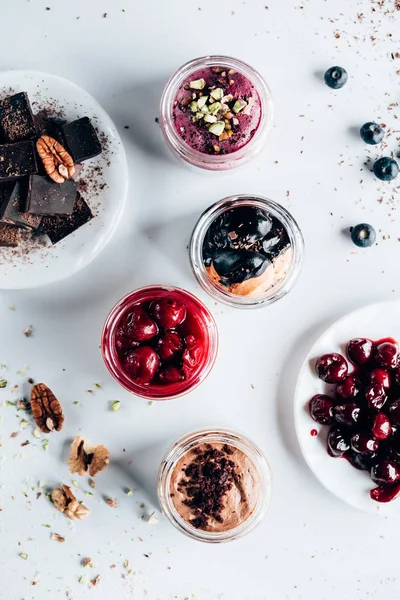 Vue de dessus de divers desserts sucrés savoureux dans des bocaux en verre — Photo de stock