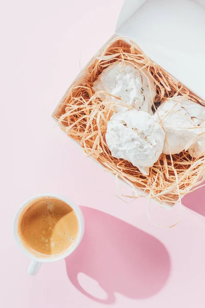 Top view of delicious meringue cookies and cup of coffee on pink — Stock Photo