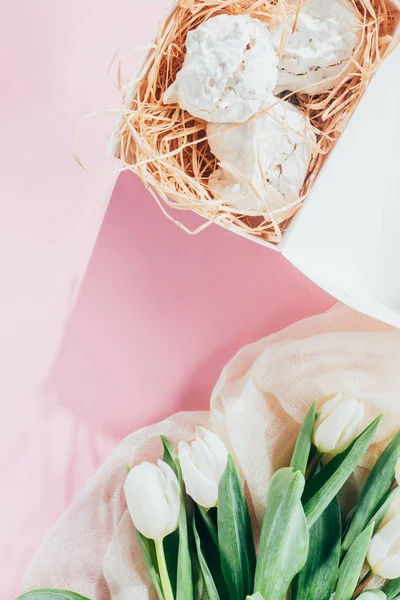 Top view of delicious meringue cookies and white tulips — Stock Photo