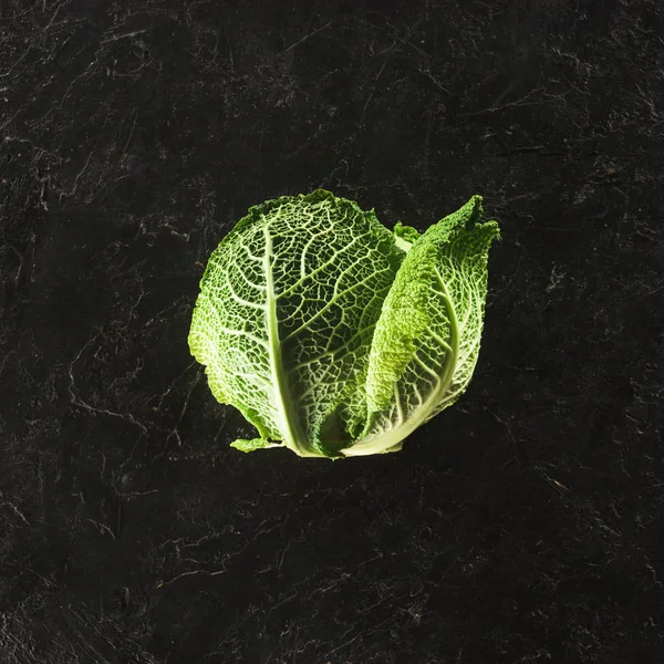 Вид свежей органической савойской капусты на черном — стоковое фото