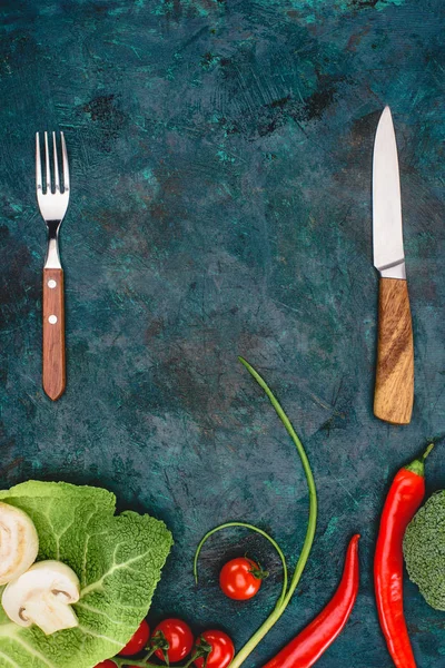 Верхний вид вилки с ножом и свежими здоровыми овощами на черном — стоковое фото