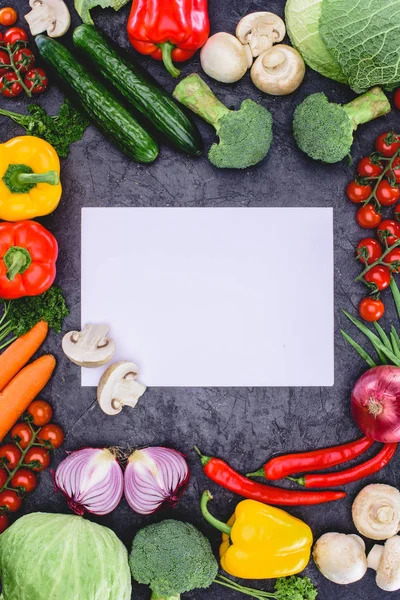 Vue du dessus des légumes crus frais et du papier blanc — Photo de stock