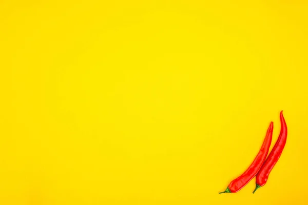 Top view of raw red chili peppers isolated on yellow background — Stock Photo