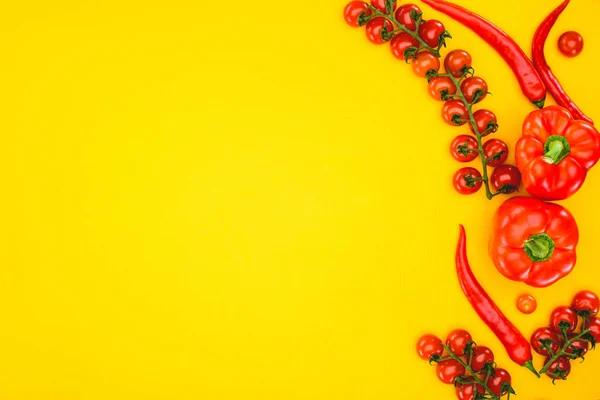 Vista superior de pimentas cruas frescas e tomates cereja isolados em amarelo — Fotografia de Stock