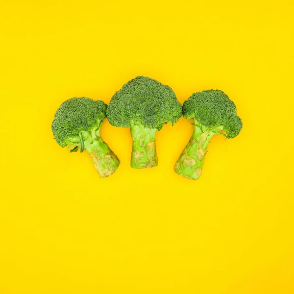 Top view of fresh green organic broccoli isolated on yellow — Stock Photo