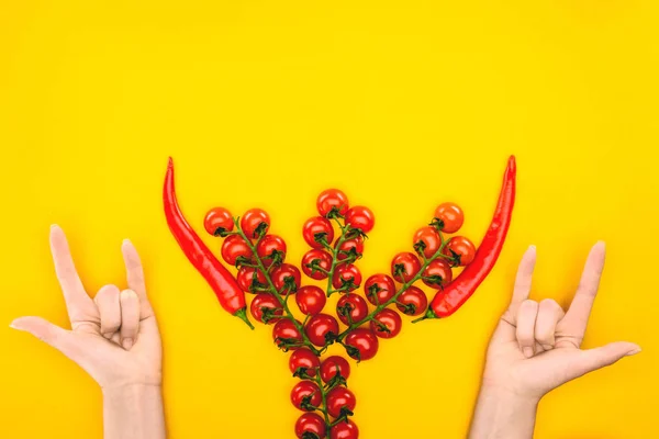 Vista superior de manos humanas y tomates frescos con pimientos aislados en amarillo - foto de stock