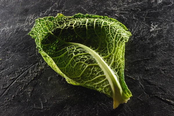 Vue rapprochée de la feuille de chou de Savoie frais et sain sur noir — Photo de stock