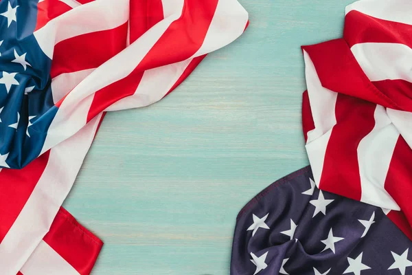 Вид зверху складених американських прапорів на синій дерев'яній поверхні, концепція дня президентів — стокове фото