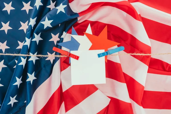 Tendido plano con bandera americana, estrellas y papel en blanco colgando de la cuerda, concepto de día de presidentes - foto de stock