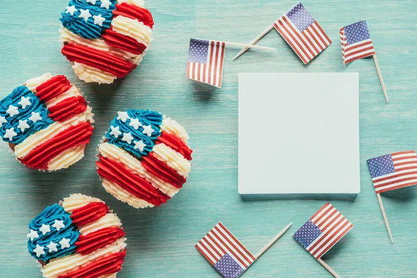 Posa piatta con cupcake organizzati e bandiere americane su tavolo in legno, concetto di celebrazione del giorno dei presidenti — Foto stock