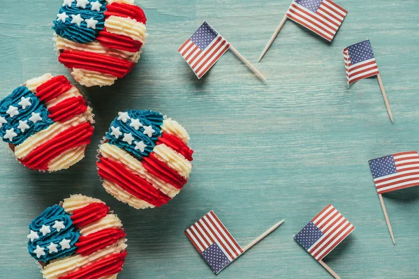 Flat lay with arranged cupcakes and american flags on wooden tabletop, presidents day celebration concept — Stock Photo