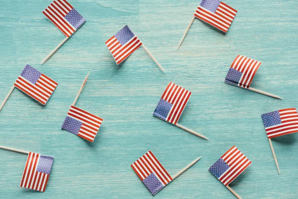 Vue de dessus des drapeaux américains disposés sur la surface bleue en bois, concept de présidents — Photo de stock