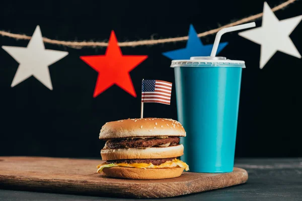Vista ravvicinata di hamburger con bandiera americana e bibita gassata, concetto di celebrazione del giorno dei presidenti — Foto stock