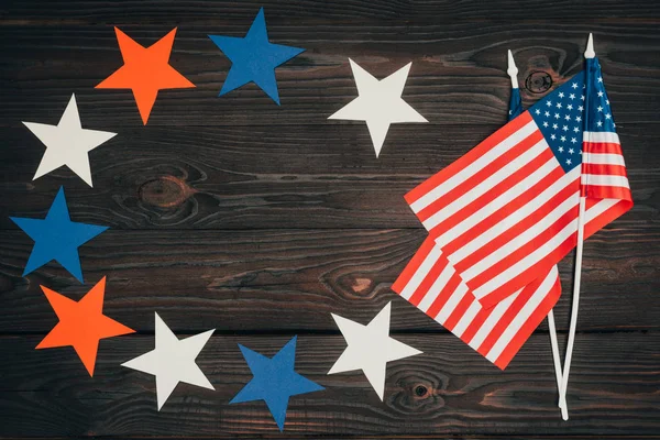 Vue de dessus des drapeaux américains disposés et des étoiles sur la surface en bois, concept de célébration de la journée des présidents — Photo de stock