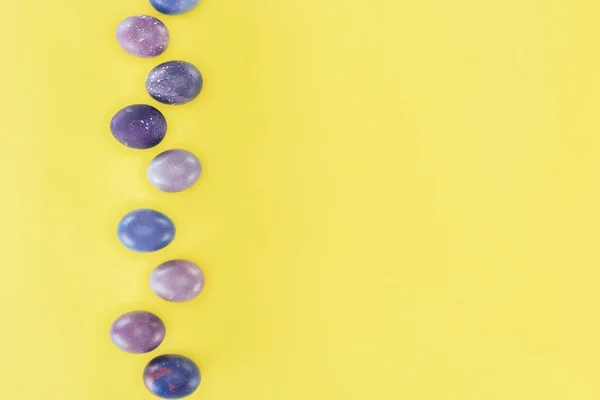 Top view of purple painted easter eggs, isolated on yellow background — Stock Photo