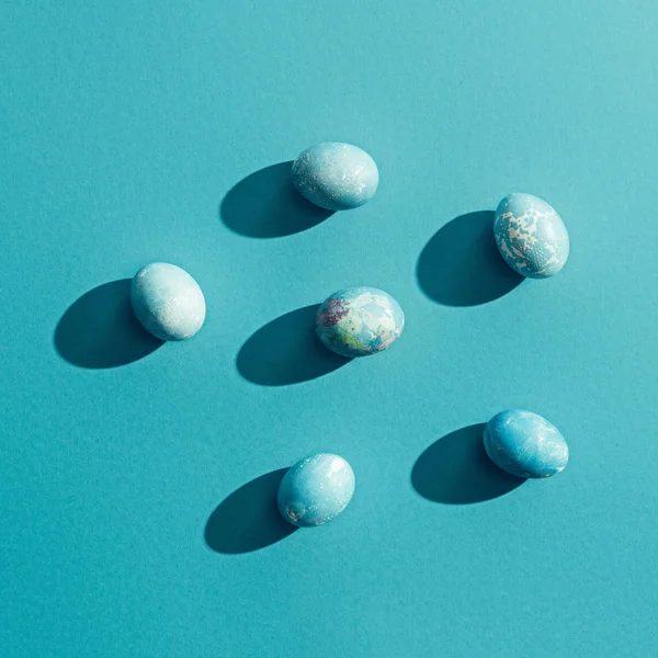 Вид зверху на блакитні похмурі великодні яйця, на синьому з тінями — стокове фото