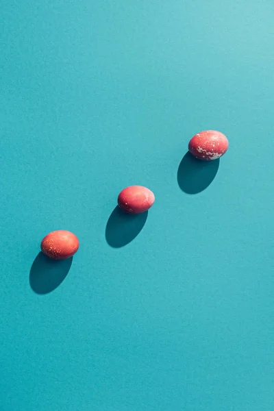 Draufsicht auf rote schäbige Ostereier, auf blau — Stockfoto