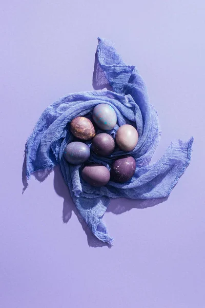 Вид зверху традиційні великодні яйця на марлі, на фіолетовому — стокове фото