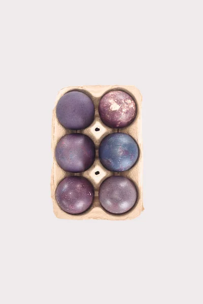 Vue du dessus des œufs de Pâques violets dans le plateau, isolés sur blanc — Photo de stock