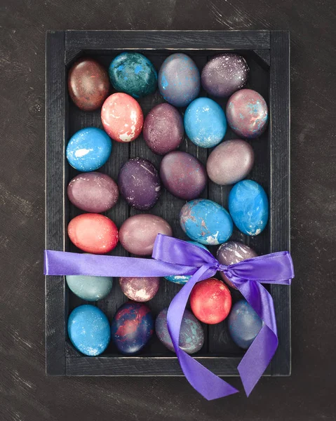 Top view of painted easter eggs in gift box with bow — Stock Photo