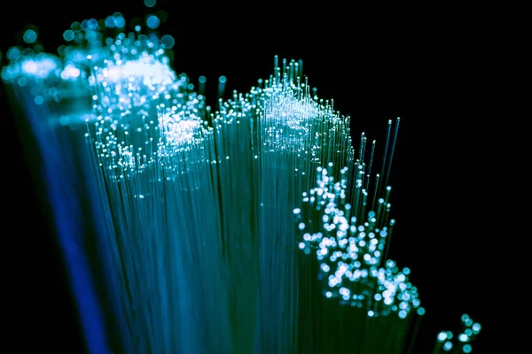 Gros plan du fond de fibre optique bleu clair brillant, technologie de communication — Photo de stock