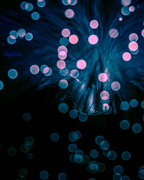 Blurred glowing fiber optics background with bokeh — Stock Photo