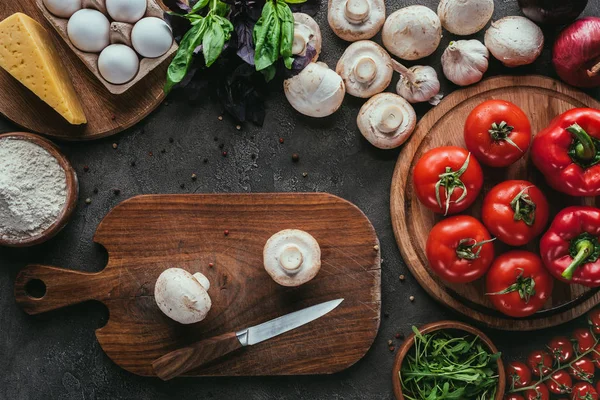 Top view of different raw ingredients for pizza and knife on concrete surface — Stock Photo