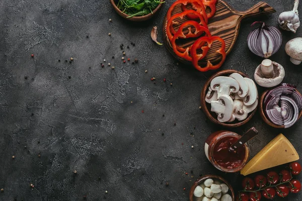 Vista superior de ingredientes de pizza cruda en mesa de hormigón - foto de stock