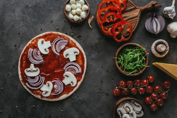 Vue de dessus de pizza non préparée avec des ingrédients sur la surface du béton — Photo de stock