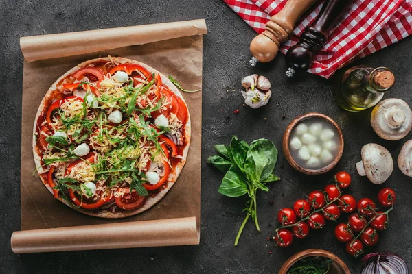 Top view of delicious pizza with ingredients on concrete table — Stock Photo