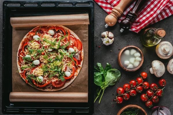 Vista dall'alto della pizza appena sfornata con ingredienti sul tavolo di cemento — Foto stock