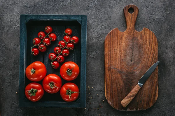 Vista superior de tomates en caja sobre superficie de hormigón - foto de stock