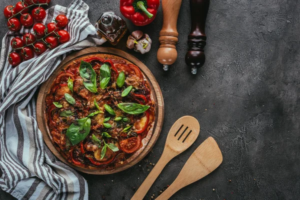 Vista superior da pizza com espátulas de madeira na mesa de concreto — Fotografia de Stock