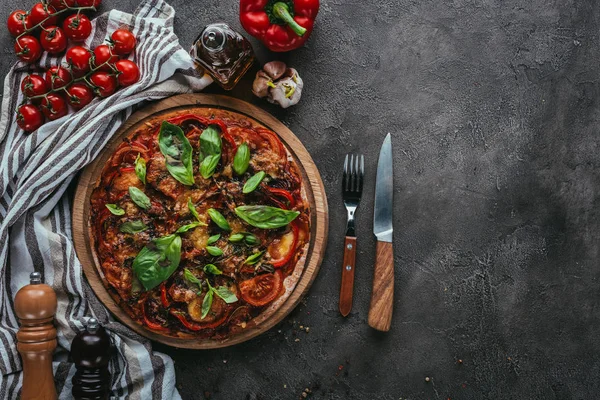 Vista superior da deliciosa pizza com garfo e faca na mesa de concreto — Stock Photo