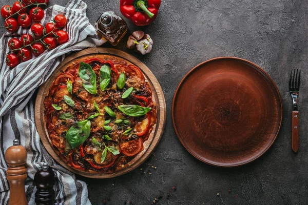 Vista superior de la deliciosa pizza con plato rústico en mesa de hormigón - foto de stock