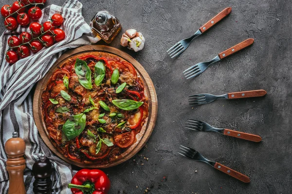 Vue de dessus de délicieuses pizzas avec fourchettes sur table en béton — Photo de stock