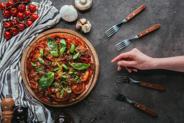 Cropped shot of woman reaching for piece of pizza — Stock Photo