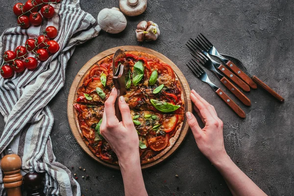 Top view of slicing pizza with circle cutter on concrete table — Stock Photo