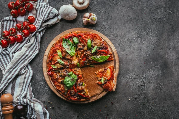 Vista superior de la deliciosa pizza recién horneada en mesa de hormigón - foto de stock