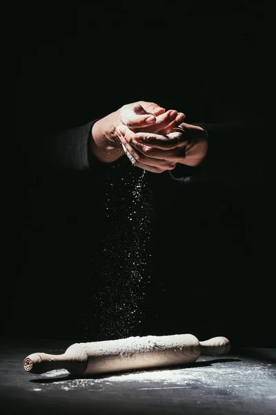 Tiro cortado de chef com as mãos cobertas de farinha e rolo de pino na mesa — Fotografia de Stock