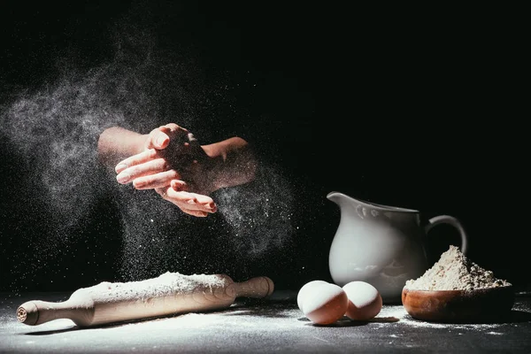 Tiro cortado de chef aplaudindo ahnds com farinha antes de fazer massa em preto — Fotografia de Stock